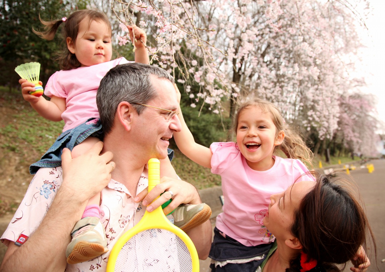 桜の前で遊ぶ外国人の親子